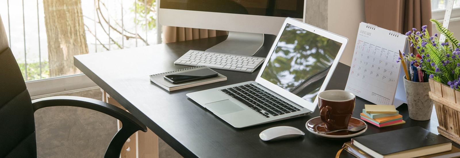 Desk with laptop, phone, coffee and other assorted items